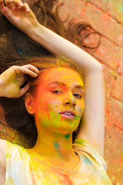 Closeup portrait de jeune femme posant avec de la poudre de couleur sèche