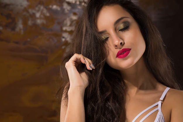 Closeup portrait de jeune femme sensuelle aux yeux fermés posant en soutien-gorge en dentelle au studio