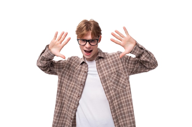 Photo closeup portrait d'un jeune homme caucasien beau avec des cheveux courts rouges dans des lunettes et une chemise sur un