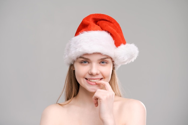 Closeup portrait joyeuse jeune femme en tenue de père Noël rouge la touche