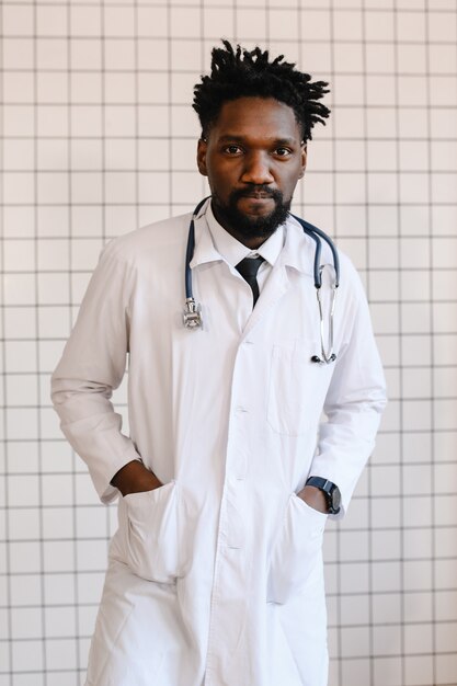 Closeup portrait de médecin noir souriant et regardant la caméra.