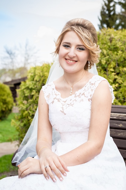 Photo closeup portrait of happy smiling bride sitting on bench at park