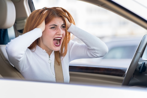 Closeup portrait of pissed off mécontent de la femme agressive en colère au volant d'une voiture en criant à quelqu'un. Expression humaine négative conckerept.