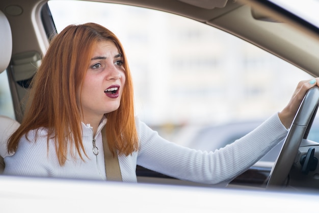 Closeup Portrait Of Pissed Off Mécontent De La Femme Agressive En Colère Au Volant D'une Voiture En Criant à Quelqu'un. Expression Humaine Négative Consept.