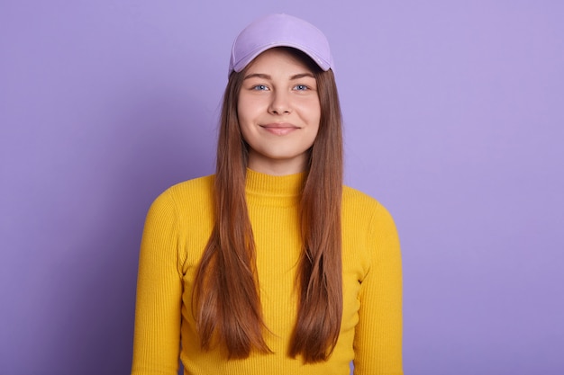 Closeup portrait of smiling girl wearing casual shirt jaune et casquette de baseball