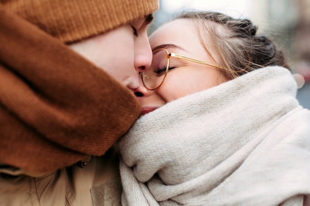 Photo closeup sensuel portrait de jeune couple s'embrasser amoureux posant dans la rue dans le portrait d'hiver froid