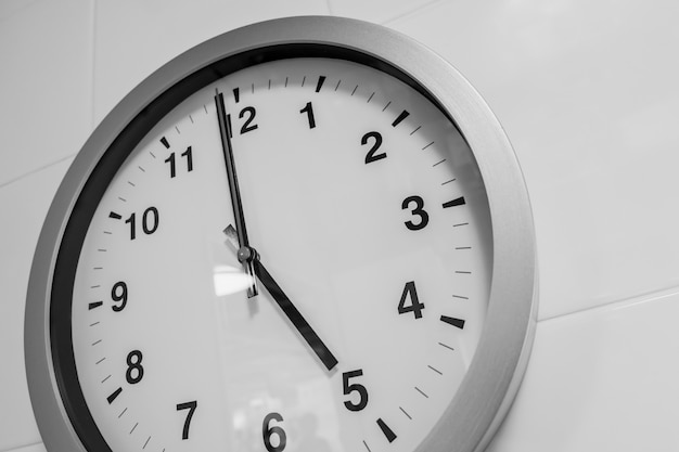 Closeup simple horloge sur le temps du mur blanc à 5 heures