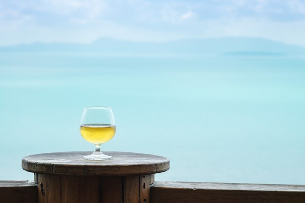 Closeup verre de vin blanc sur la table à la terrasse avec vue sur la mer