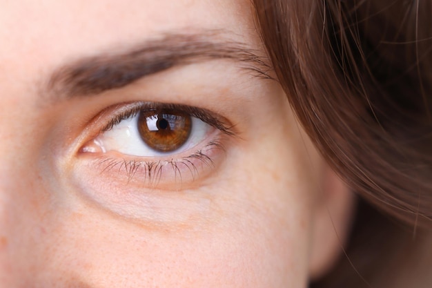 Closeup visage féminin fille avec de beaux yeux bruns et beauté naturelle des cheveux sans