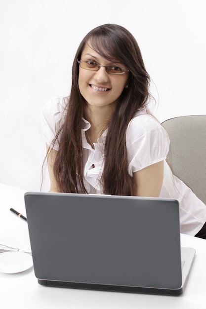 Closeupsmiling femme d'affaires assis à un bureau