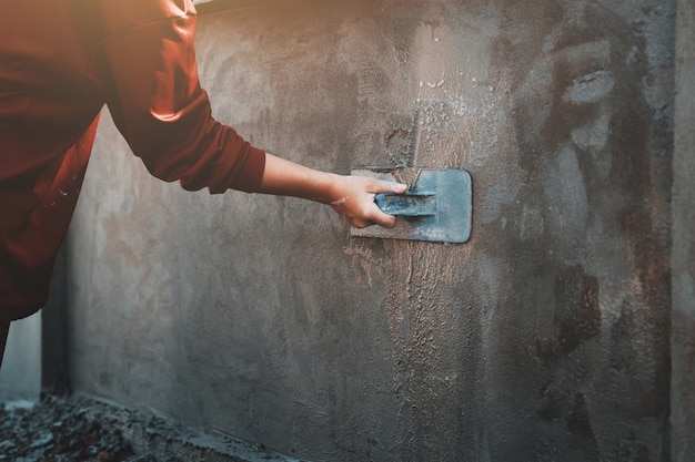 Closup Main D'ouvriers Plâtrant Sur Un Mur Extérieur Sur Un Chantier De Construction