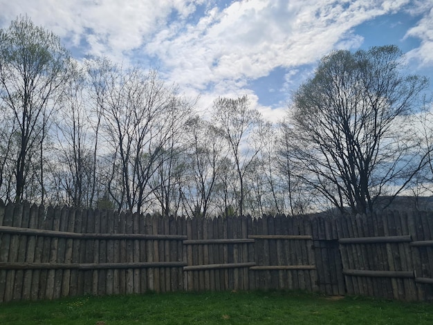 Une clôture en bois avec des arbres en arrière-plan