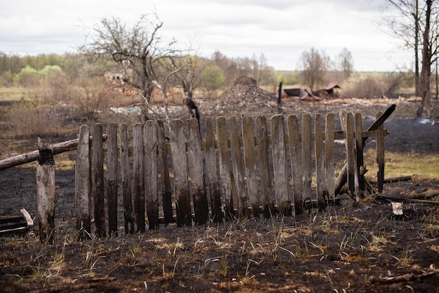 Clôture en bois brûlé noir, beaucoup de déchets endommagés