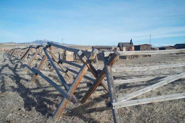 Une clôture en bois sur le champ contre le ciel