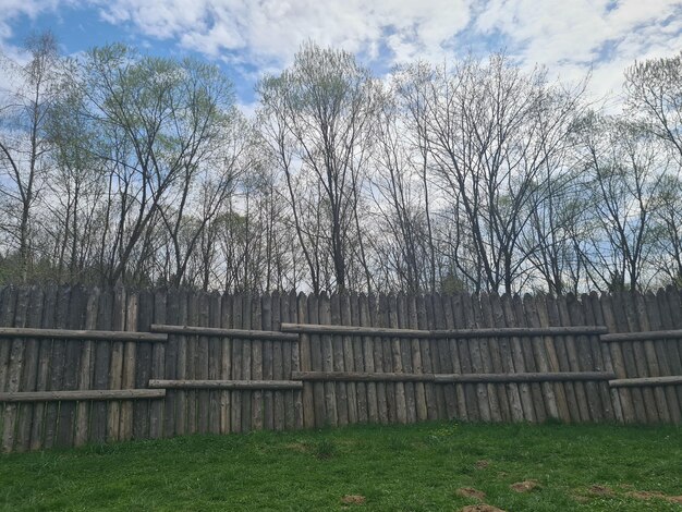 Une clôture en bois avec un ciel bleu derrière elle