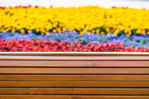 Une clôture en bois d'un parterre de fleurs en barreaux vernissés avec un parterre de fleurs en arrière-plan