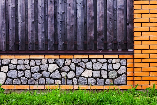 Clôture en brique avec travées en bois et gravier gris