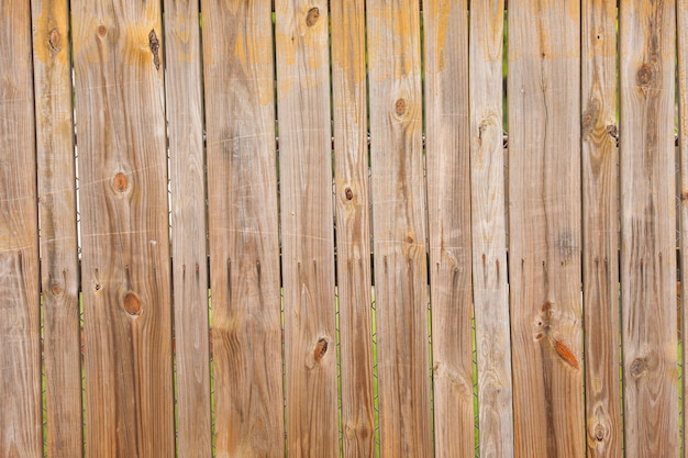 Une clôture devant une clôture en bois