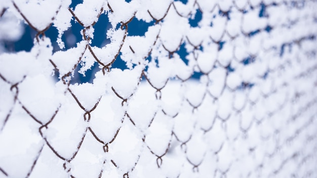 Photo clôture de grille dans la neige. beaucoup de neige sur la clôture de fer