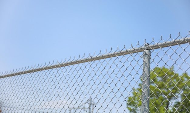 Clôture à mailles losangées avec fil de fer barbelé, symbole de la restriction de sécurité de confinement et de la division être