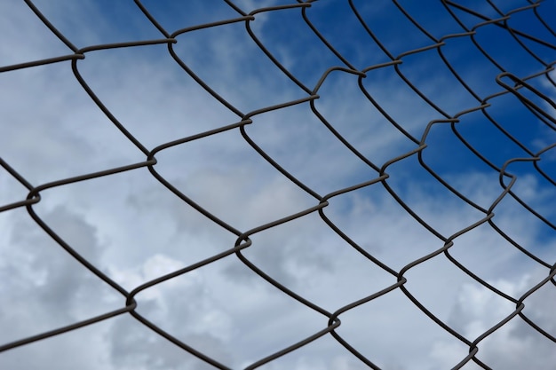 Clôture métallique contre le ciel bleu avec des nuages