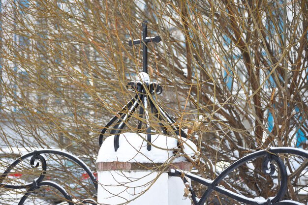 Clôture métallique avec une croix dans les branches