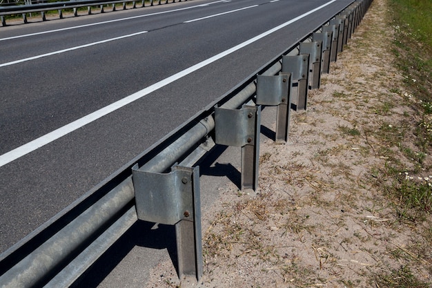 Clôtures en acier sur la route pour assurer la sécurité des voitures, partie d'une structure métallique complexe et solide qui assure la sécurité sur la route