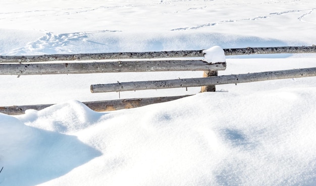 Clôtures en bois dans la neige. Fond d'hiver.