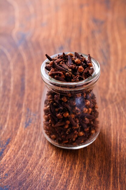 Clous de girofle. Assaisonnement sec pour la cuisson et les boissons sur un simple fond en bois ancien. Mise au point sélective