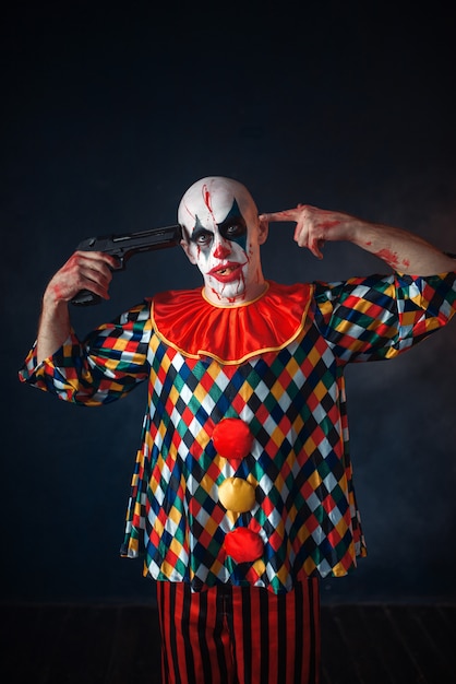 Clown sanglant fou avec un pistolet dans sa bouche