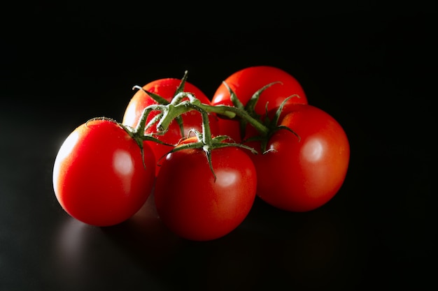 Cluster tomate rouge sur fond noir