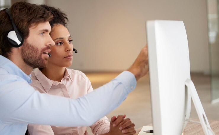 Photo coaching homme femme et centre d'appels à l'ordinateur pour le développement de la formation ou le point à l'écran support technique du travail d'équipe crm ou apprentissage pour l'expérience client avec la diversité au bureau pour la collaboration