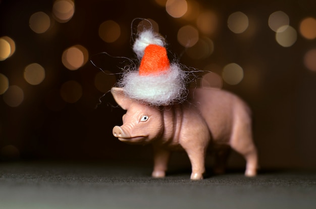 Cochon jouet dur dans un bonnet rouge