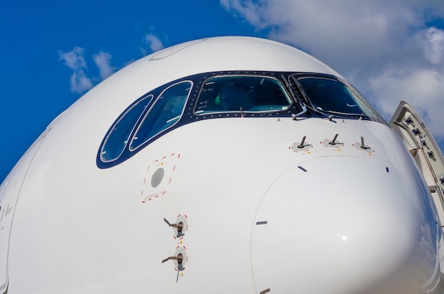 Cockpit de nez d'avion de passagers dans le ciel de nuages bleus