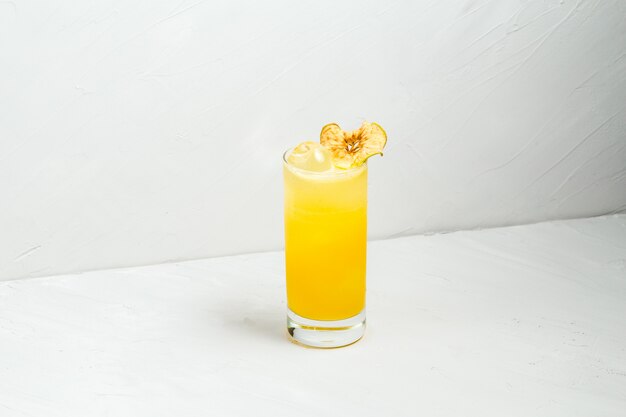 Cocktail d'alcool jaune de fruits frais dans un highball