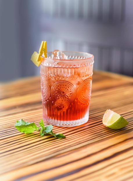 Cocktail d'alcool sur une table en bois contre un mur sombre avec espace de copie