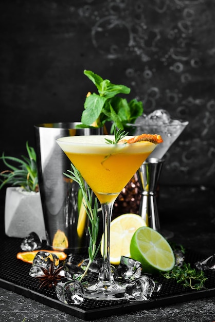 Cocktail alcoolisé à l'argousier et à l'orange avec de la liqueur dans un verre Sur fond de pierre noire Barre de menus