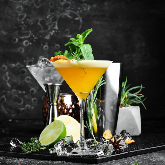 Cocktail alcoolisé à l'argousier et à l'orange avec de la liqueur dans un verre Sur fond de pierre noire Barre de menus