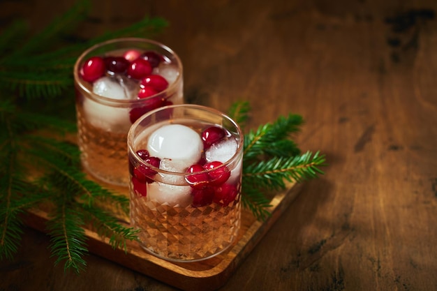 Photo cocktail alcoolisé ou cocktail non alcoolisé avec de la vodka et des canneberges avec de la glace avec des branches de sapin sur