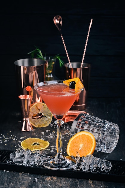 Cocktail alcoolisé Cosmopolitan Sur le bar fond noir