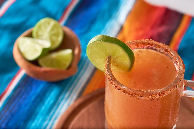 Cocktail alcoolisé mexicain Michelada avec de la bière jus de citron vert jus de tomate