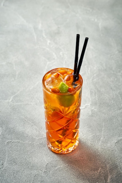 Cocktail alcoolisé à l'orange avec des oranges et de la glace dans un verre Fond de béton Aperol spritz