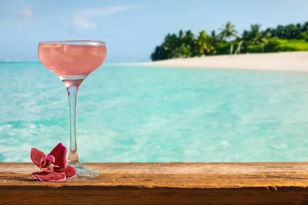 Cocktail alcoolisé rose cosmopolite Verre de cocktail d'été sur le bar de la plage tropicale