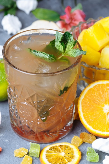 Cocktail d'ananas frais et rafraîchissant au citron vert et à la menthe pour une chaude journée d'été sur un fond gris déco...