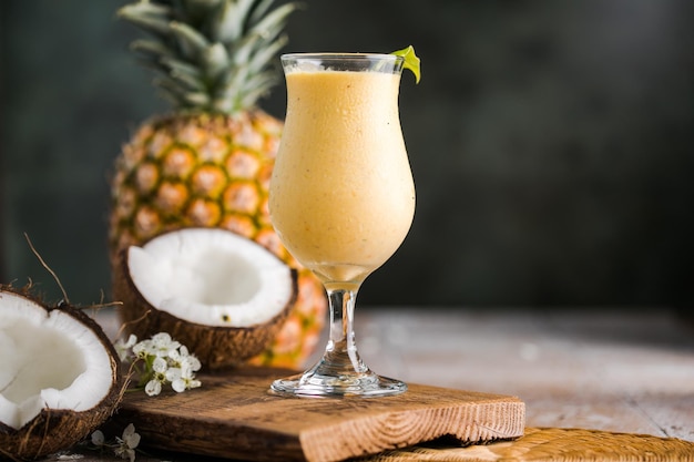 Cocktail d'ananas pina colada ou Lassi sur une table en bois rustique