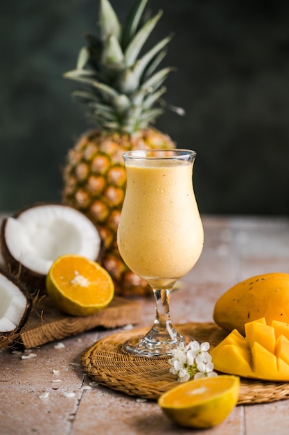 Cocktail d'ananas pina colada ou Lassi sur une table en bois rustique