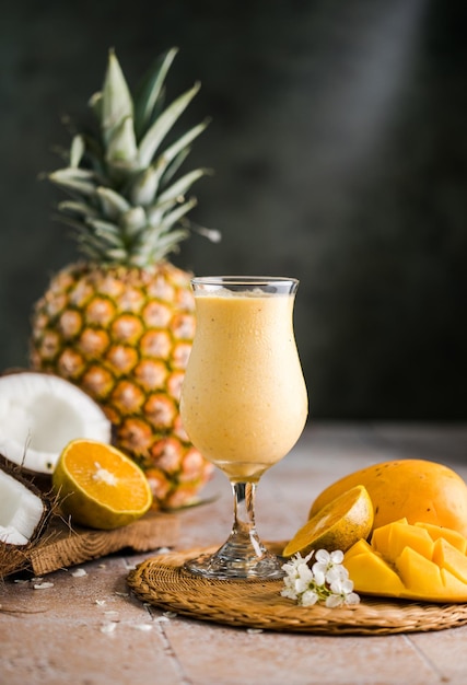 Cocktail d'ananas pina colada ou Lassi sur une table en bois rustique