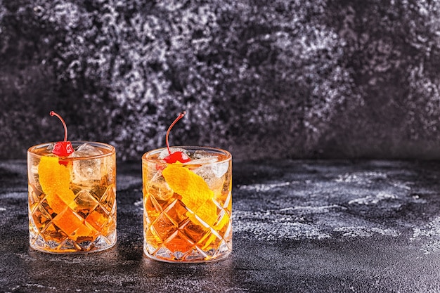 Cocktail à l'ancienne avec des cerises et une touche d'orange, mise au point sélective.