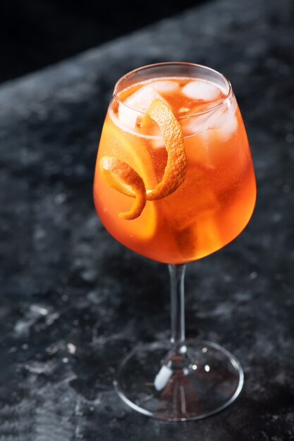 Cocktail aperol spritz italien classique en verre sur un fond sombre, gros plan