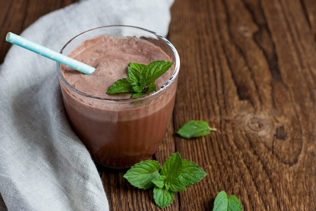 Cocktail au chocolat, boisson ou smoothie dans un verre avec un brin de menthe et une paille réutilisable